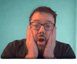 a man with his hands on his face with a surprised look